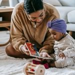 Woman showing a book to a toddler
