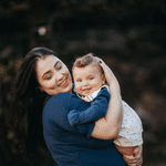 Woman holding a toddler and smiling