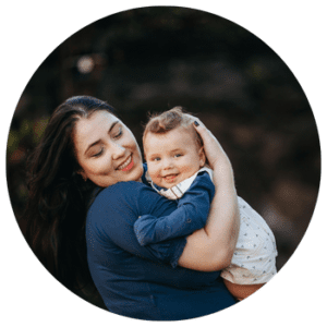 Mother holding her baby outdoors, both smiling